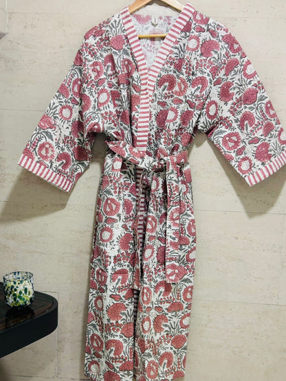 Floral patterned robe on a hanger against a tiled wall.