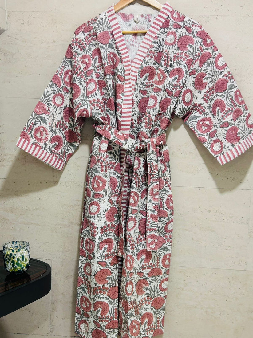 Floral patterned robe on a hanger against a tiled wall.